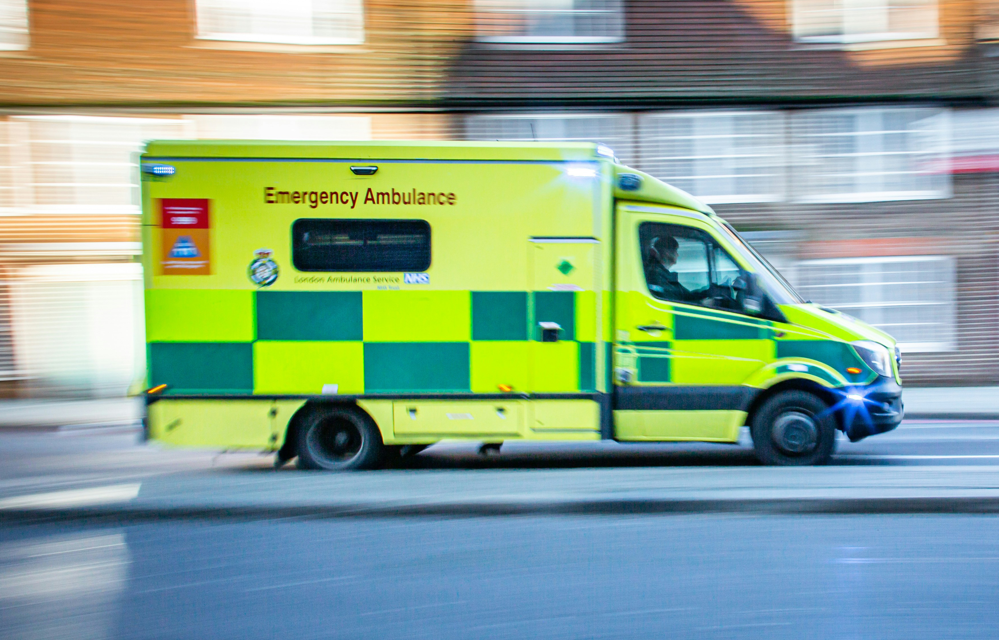 Ambulance driving quickly along a road