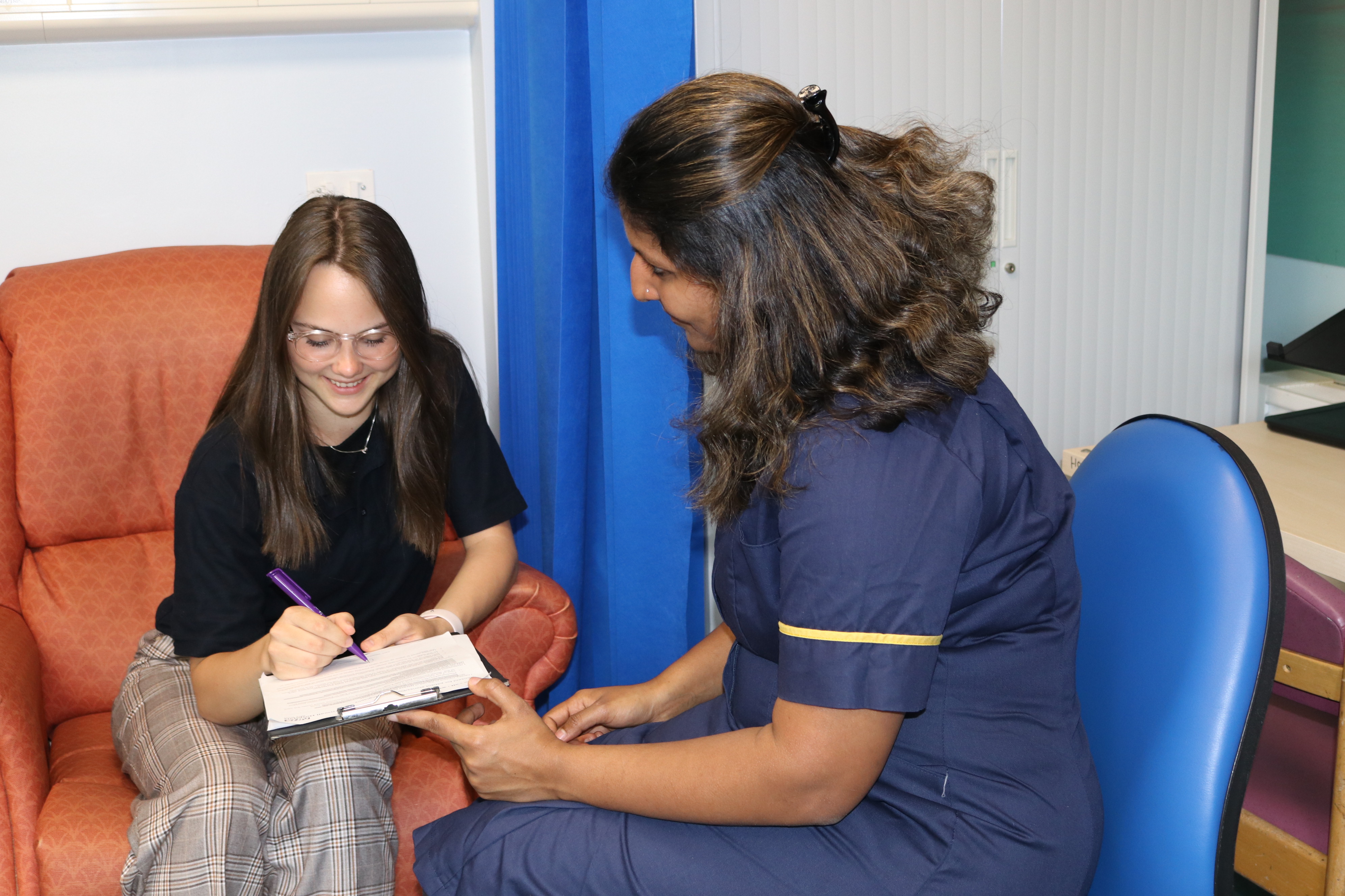 Medical research nurse filling out a form with a patient