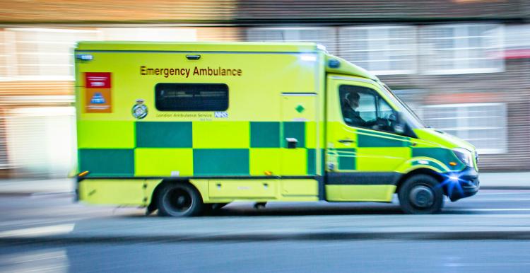 Ambulance driving quickly along a road