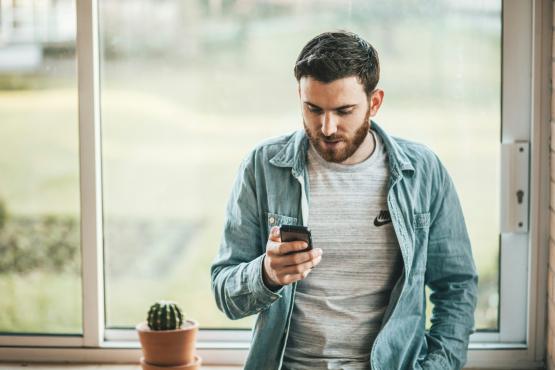 Man looking at his phone at home